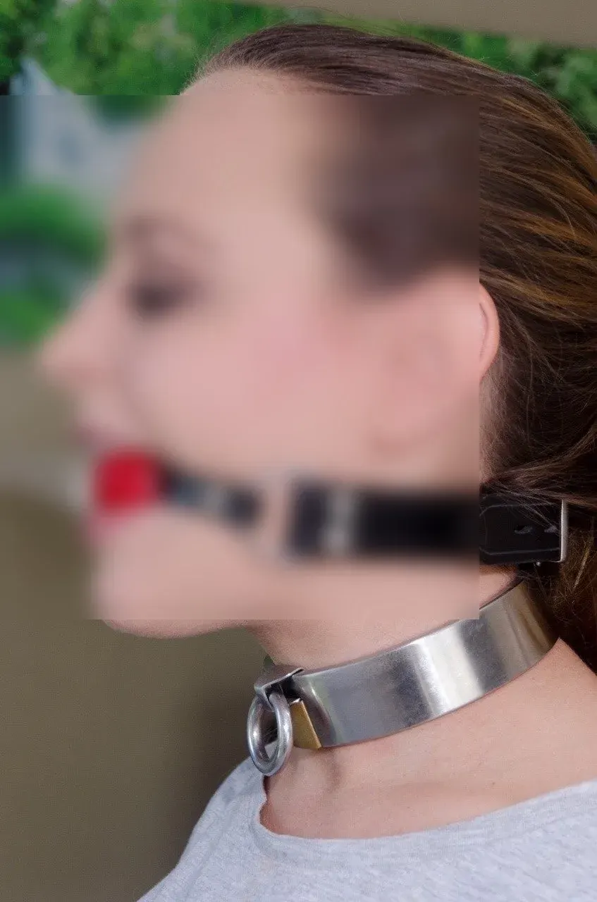 Profile portrait of a person wearing a metallic neck collar and black head strap for a discreet BDSM profile page Profile portrait of a person wearing a metallic neck collar and black head strap for a discreet BDSM profile page
