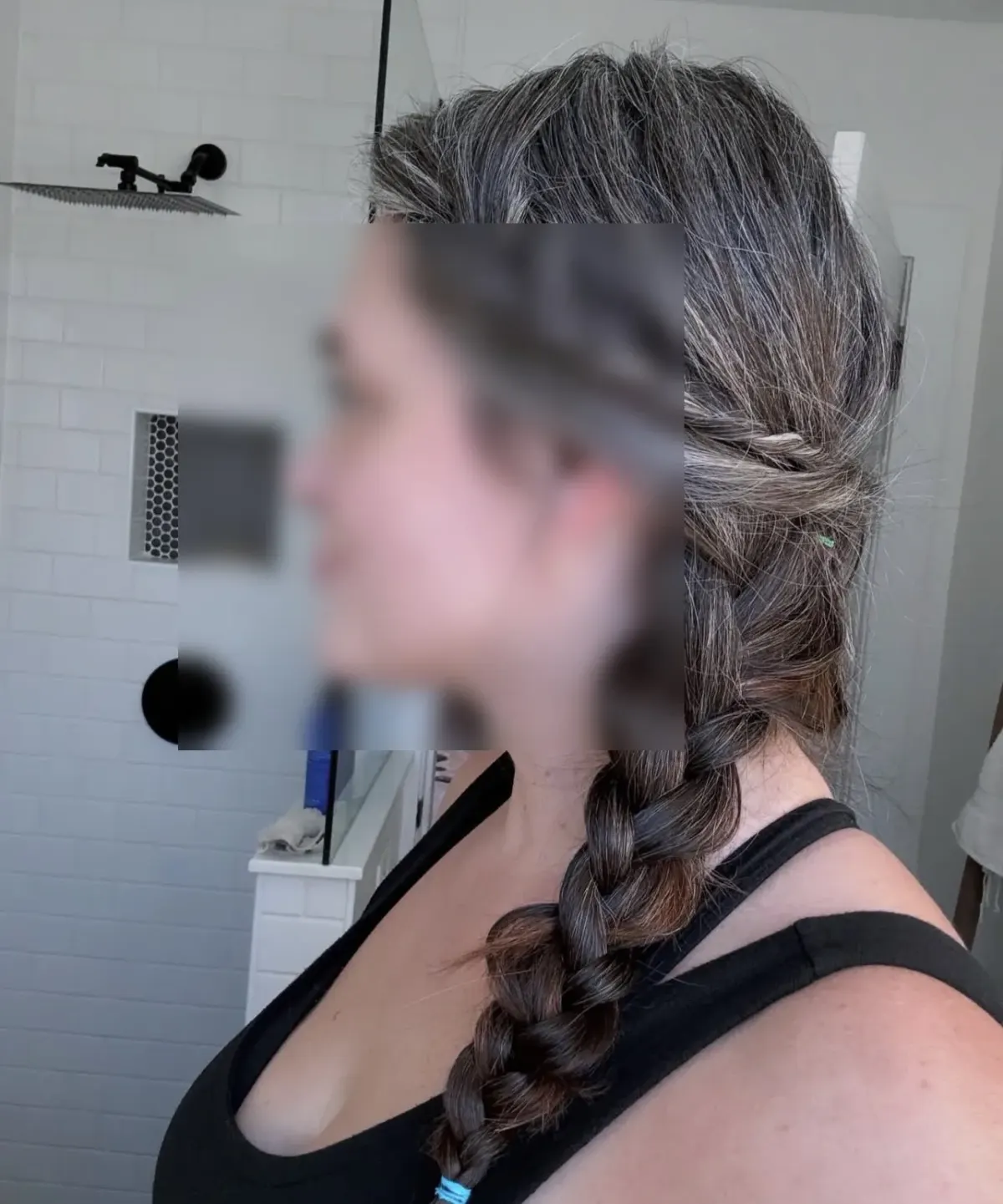 Person with braided hair and obscured face in a bathroom, suggesting discretion for kink-aware dating privacy. Person with braided hair and obscured face in a bathroom, suggesting discretion for kink-aware dating privacy.